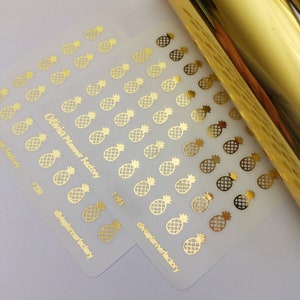 May include: Two sheets of clear sticker paper with gold pineapple designs. The sticker sheets are labeled "Olivia Planner Factory" and "F220".