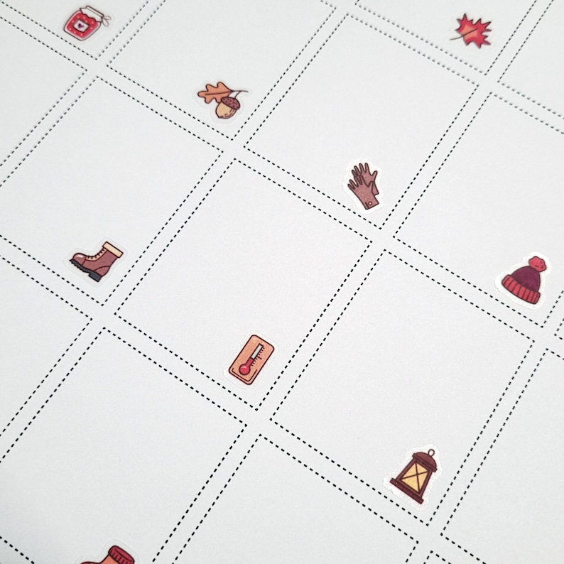 May include: A white sheet of paper with a grid of squares. Each square contains a small, colorful illustration of a fall-themed item, such as a jar of jam, a leaf, a mitten, a boot, an acorn, a thermometer, a lantern, and a beanie.