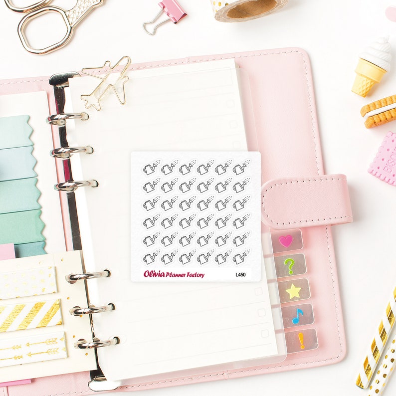 Op de afbeelding: Een vel stickers met een herhalend patroon van gieters. De stickers zijn wit met zwarte contouren en zijn in een rasterpatroon gerangschikt. Het vel is gelabeld "Olivia Planner Factory L450".