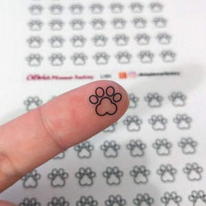 May include: A sheet of clear stickers with black paw print designs. The paw prints are about 1/2 inch in diameter.
