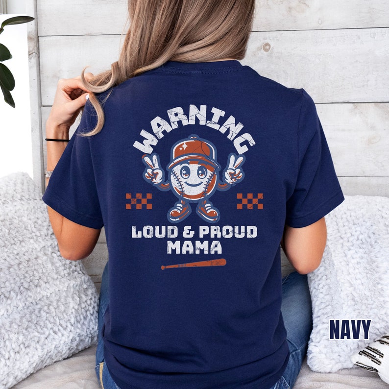 May include: A navy blue t-shirt with a baseball-themed graphic that says "Warning Loud & Proud Mama".