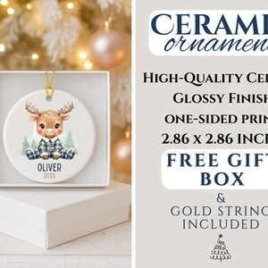 May include: A ceramic Christmas ornament featuring a cartoon moose in a blue plaid outfit. The ornament is 2.86 x 2.86 inches and comes with a free gift box and gold string. The ornament has the name "OLIVER" and the year "2025".