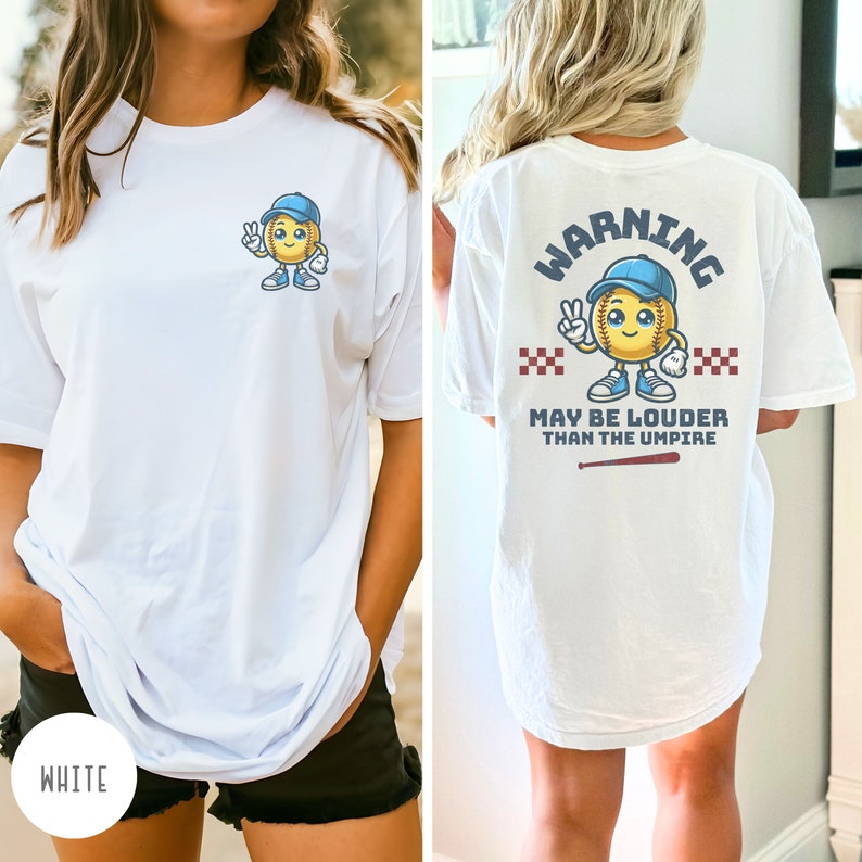 May include: White t-shirt with a softball character graphic on the front and the text "WARNING MAY BE LOUDER THAN THE UMPIRE" on the back. The softball character is wearing a blue baseball cap and has a peace sign.