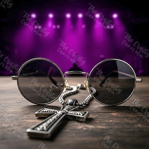 Könnte beinhalten: Eine runde, silberfarbene Sonnenbrille mit dunklen Gläsern liegt auf einer Holzoberfläche, zusammen mit einem silbernen Kreuzanhänger an einer Kette. Der Hintergrund zeigt eine verschwommene lila Bühne mit Scheinwerfern.