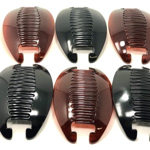 May include: Six banana hair clips in two colors: black and a translucent reddish-brown. Each clip has a curved, oval shape with a row of teeth for securing hair. The clips are made of a shiny plastic material.