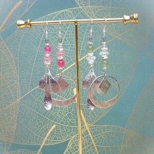 Peut inclure: Une paire de boucles d'oreilles pendantes en argent avec des formes géométriques et des perles de pierres précieuses roses et vertes.