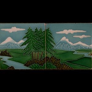 May include: Two square ceramic tiles showing a landscape scene. The tiles feature a light blue sky with white clouds, green trees, rolling green hills, a river, and snow-capped mountains. The artwork has a vintage, hand-painted aesthetic.