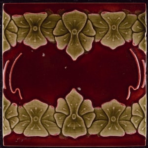 May include: Square decorative tile with a burgundy centre and an olive green floral border. The floral border has a cracked, aged appearance. The tile has a dark border.