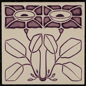 May include: A purple and white ceramic tile with a floral design. The tile features two stylised flowers with leaves and stems.
