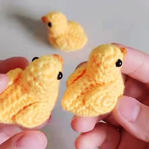 Puede incluir: Tres pollitos amarillos de crochet con ojos negros. Los pollitos son peque&ntilde;os y se sostienen en manos.