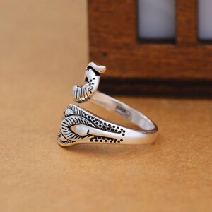 Peut inclure: Une bague en argent avec un motif d&eacute;taill&eacute; d'un oiseau aux ailes d&eacute;ploy&eacute;es. La bague est ouverte et r&eacute;glable.