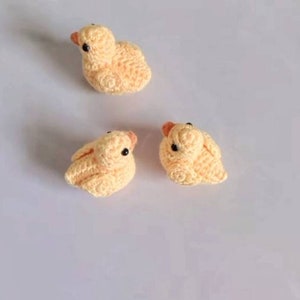 Puede incluir: Tres peque&ntilde;os patitos amarillos de crochet con ojos negros.