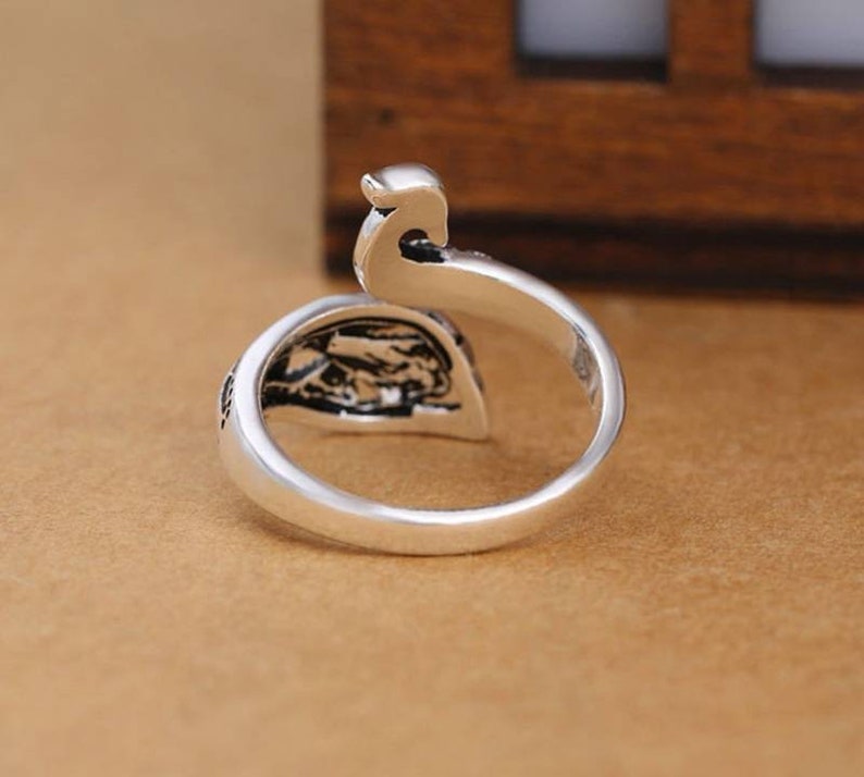 Peut inclure: Une bague en argent avec un motif de paon. La bague est ouverte et r&eacute;glable.