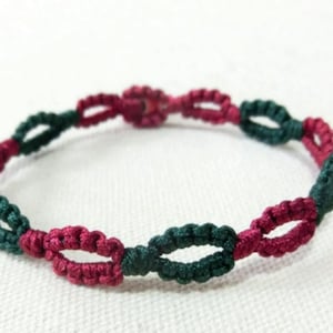 May include: A green and burgundy braided bracelet with a knotted design.
