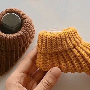 May include: Two pairs of knitted baby booties. One pair is brown and the other pair is yellow.