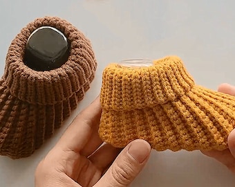 May include: Two pairs of knitted baby booties. One pair is brown and the other pair is yellow.