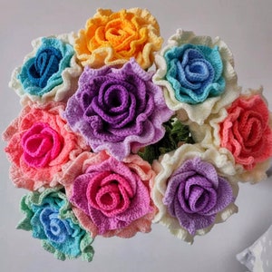 May include: A bouquet of crocheted roses in a rainbow of colours, including pink, purple, blue, yellow, and white.