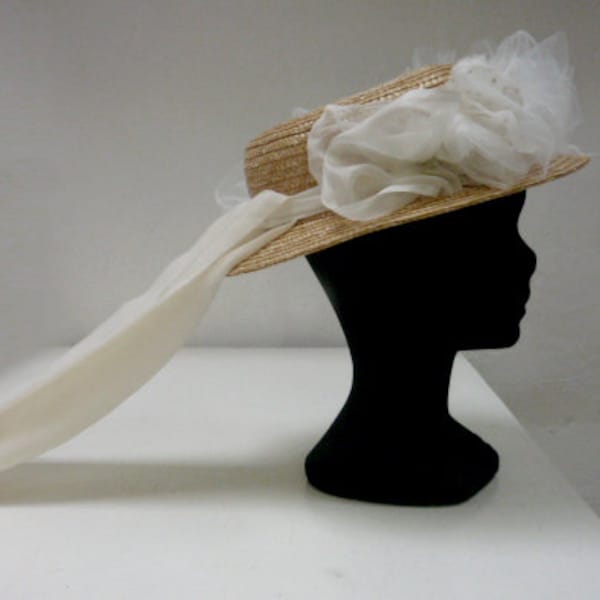 Straw hat of bride, wedding Boater has flowers in tulle and ribbons