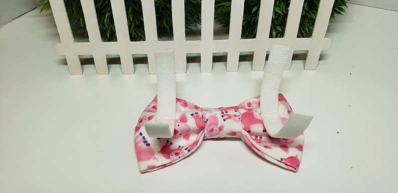 This adorable Pig Bow Tie has a White background with cute Pink Pigs. It is made with Cotton Fabric and Interfacing with either 2 hook and loop attachments.