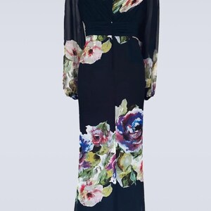 Puede incluir: Vestido largo azul marino oscuro con estampado floral. El vestido presenta mangas largas y transparentes y un corpi&ntilde;o ajustado. El estampado floral incluye flores rosas, moradas y blancas. Adecuado para ocasiones formales.