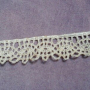 May include: White crocheted lace trim with a delicate floral pattern.