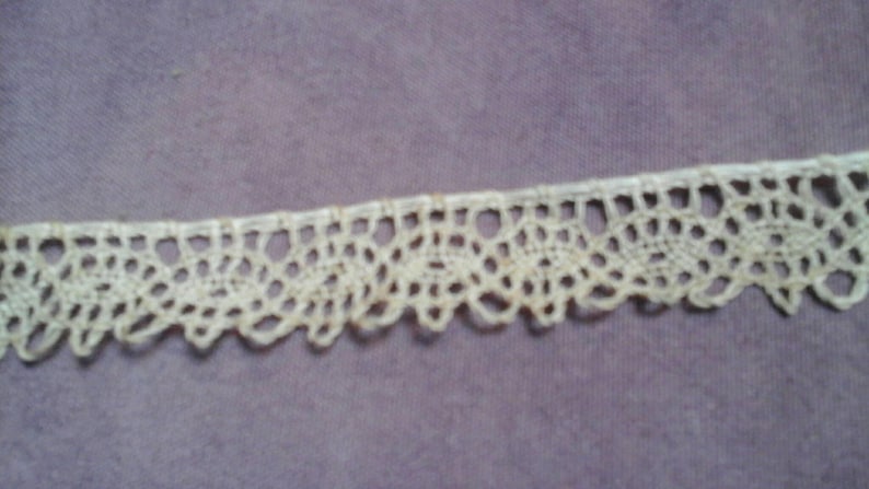 May include: White crocheted lace trim with a delicate floral pattern.