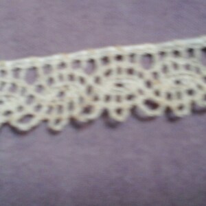 May include: White crocheted lace trim with a delicate floral pattern.