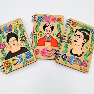 notebook made of compresse wood  with the image of frida and hand painted by indigenous mexicans in bright colors with motifs  doves flowers