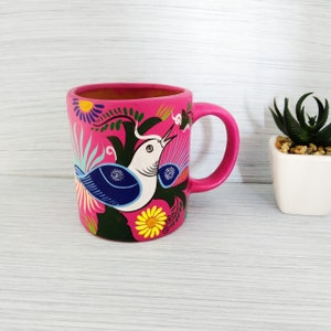 decoratice mug made of clay and hand painted by indigenous mexicans with decoration in many colors such as flowers, plants, doves.