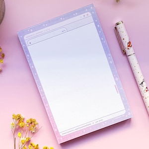 May include: A notepad with a light purple and white background with a white border and a light blue browser window design. The notepad has a light blue and white grid pattern. The notepad is on a pink surface with a pen with a white background and a gold design of fish.