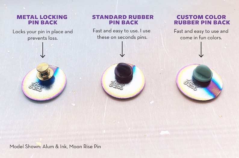 Op de afbeelding: Afbeelding van drie pin backs: metalen vergrendeling, standaard rubber en rubber in aangepaste kleuren. Tekst beschrijft elk type: "Vergrendelt uw pin op zijn plaats", "Snel en gemakkelijk te gebruiken" en "verkrijgbaar in leuke kleuren". De pins zijn iriserend.