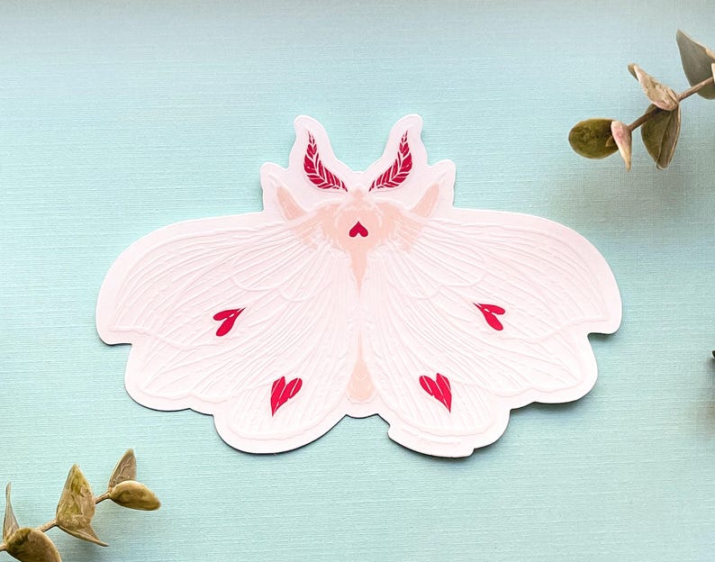 May include: White moth sticker with red heart accents. The moth has feathery antennae and wings with a delicate, textured design.