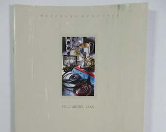 May include: A brochure for Mercedes-Benz featuring a silver trophy, a steering wheel, and a red and blue ribbon. The text "Full Model Line" is printed below the image.