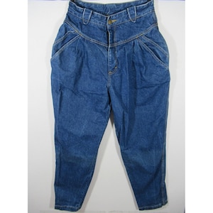 May include: High-waisted blue denim jeans with a classic design. The jeans feature a button closure, front pockets, and pleats at the waist. The denim has a medium wash and a slightly faded appearance, giving them a vintage look. The jeans have a tapered leg.