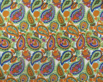 May include: A vibrant fabric featuring a repeating paisley pattern. The design includes orange, green, blue, and pink paisley shapes on a white background. The fabric has a retro, bohemian aesthetic.