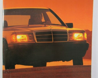 May include: A vintage brochure for the 190 Class Mercedes-Benz from 1987. The brochure features a photo of a silver Mercedes-Benz 190 Class driving towards a sunset. The text "MERCEDES-BENZ 1987" is at the top of the brochure, and "190 CLASS" is at the top right.