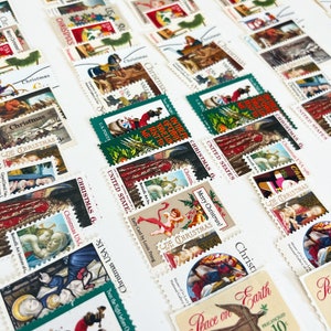 Pode incluir: Uma cole&ccedil;&atilde;o de selos de Natal vintage com v&aacute;rias cenas festivas, incluindo anjos, Papai Noel e paisagens de inverno. Os selos s&atilde;o de diferentes cores e tamanhos, e alguns foram cancelados com um carimbo postal.