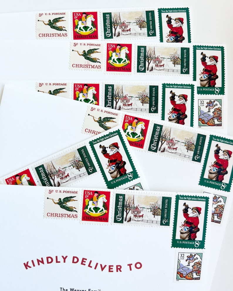 Pode incluir: Um envelope branco com a inscri&ccedil;&atilde;o vermelha "KINDLY DELIVER TO" e a inscri&ccedil;&atilde;o vermelha "The Weaver Family". O envelope &eacute; decorado com v&aacute;rios selos de Natal vintage que mostram imagens do Papai Noel, um cavalo de balan&ccedil;o, um anjo e uma cena de inverno. Os selos s&atilde;o do Servi&ccedil;o Postal dos Estados Unidos e mostram o texto "Christmas" e "U.S. Postage".