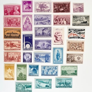 May include: A collection of vintage United States postage stamps featuring various historical scenes, portraits, and landmarks. Each stamp is rectangular with serrated edges, displaying diverse colors including red, blue, purple, green, and brown ink.