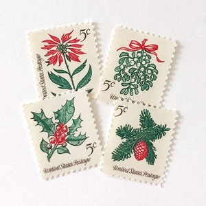 Pode incluir: Quatro selos postais vintage dos Estados Unidos com uma denominação de 5 centavos. Os selos apresentam ilustrações de uma poinsétia vermelha, visco verde com uma fita vermelha, folhas de azevinho com bagas vermelhas e um ramo de pinheiro.