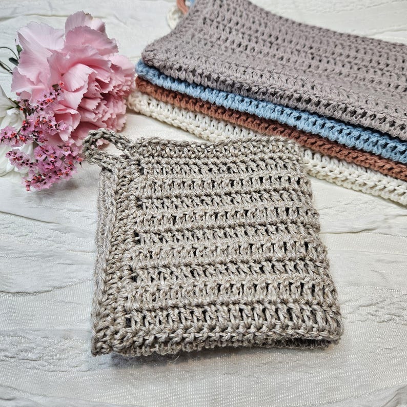 May include: A set of four crocheted dishcloths in various shades of brown, blue, and white. The dishcloths are made with a textured, open weave pattern.