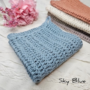 May include: A sky blue crocheted dishcloth or kitchen towel. The cloth is made with a textured stitch pattern.