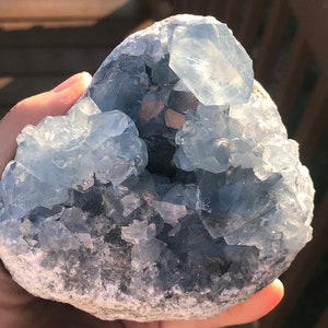 以下が含まれることがあります： 自然な表面を持つ、大きな青いセレスタイトの結晶クラスター。結晶は様々な形とサイズで、いくつかの大きな結晶がポイントを形成しています。このクラスターは、この人気のある結晶の美しい例です。