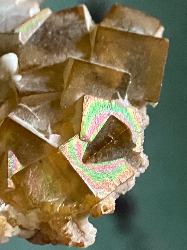 May include: A cluster of iridescent brown calcite crystals with a light brown color and a white base.