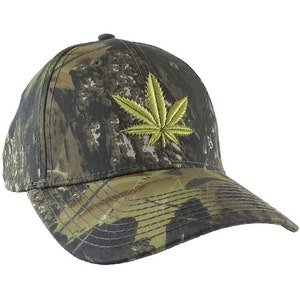 May include: A camouflage baseball cap with a green marijuana leaf embroidered on the front.