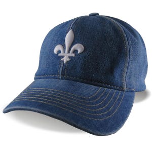 May include: A blue denim baseball cap with a white fleur-de-lis embroidered on the front. The cap has a curved brim and a button on top. The stitching is a light tan color.