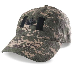 Op de afbeelding: Een camouflage baseballpet met een Canadees vlagontwerp. De pet heeft een digitaal camouflagepatroon in groen, bruin en beige. De Canadese vlag wordt weergegeven door twee zwarte rechthoeken en een zwart esdoornblad.