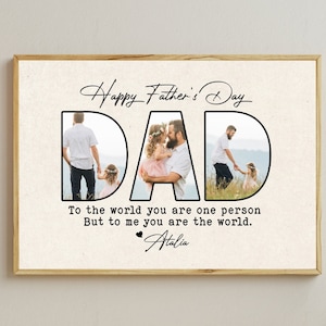 Op de afbeelding: Een ingelijste Vaderdagprint met het woord "DAD" in grote, zwarte letters. De letters bevatten familiefoto's. De tekst erboven luidt "Happy Father's Day" en daaronder "To the world you are one person, But to me you are the world."
