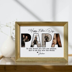 Op de afbeelding: Een ingelijst Vaderdagcadeau met een goudkleurige lijst. Het woord "PAPA" wordt gevormd door foto's van een vader en kind. De tekst luidt "Happy Father's Day" en "Voor de wereld ben je &eacute;&eacute;n persoon, maar voor mij ben je de wereld." Ondertekend "Jackson."
