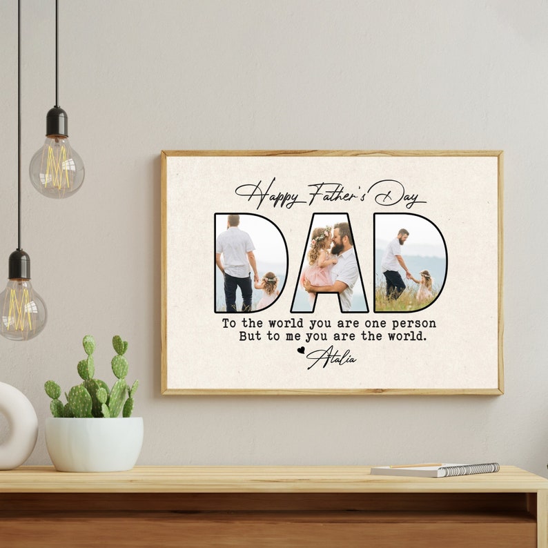 Op de afbeelding: Een ingelijste Vaderdagprint met het woord "DAD" in grote, zwarte letters. De letters bevatten familiefoto's. De tekst erboven luidt "Happy Father's Day" en daaronder "To the world you are one person, But to me you are the world."